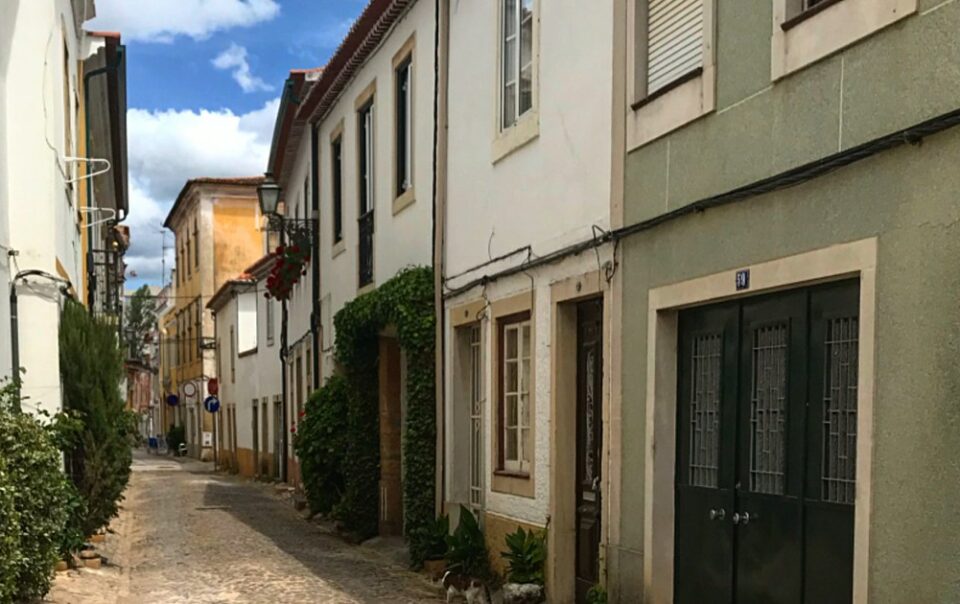 Rue pavée bordée de façades anciennes au Portugal, illustrant un quartier résidentiel